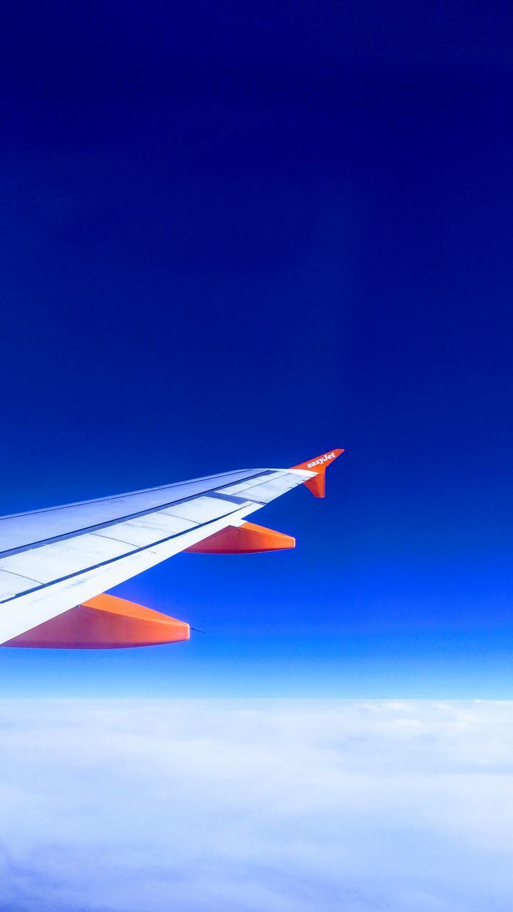 AIRPLANE FLYING AGAINST BLUE SKY