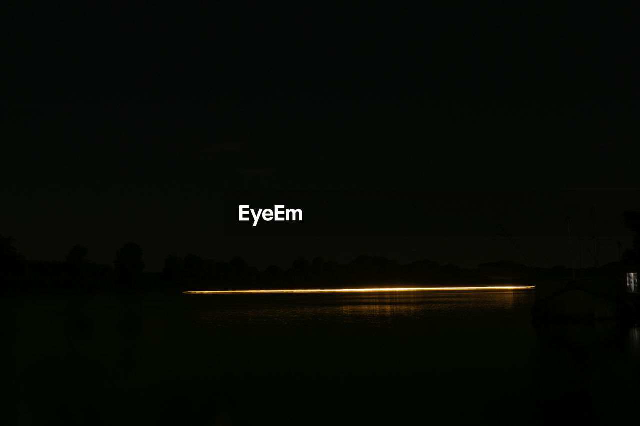 VIEW OF LAKE AGAINST SKY AT NIGHT