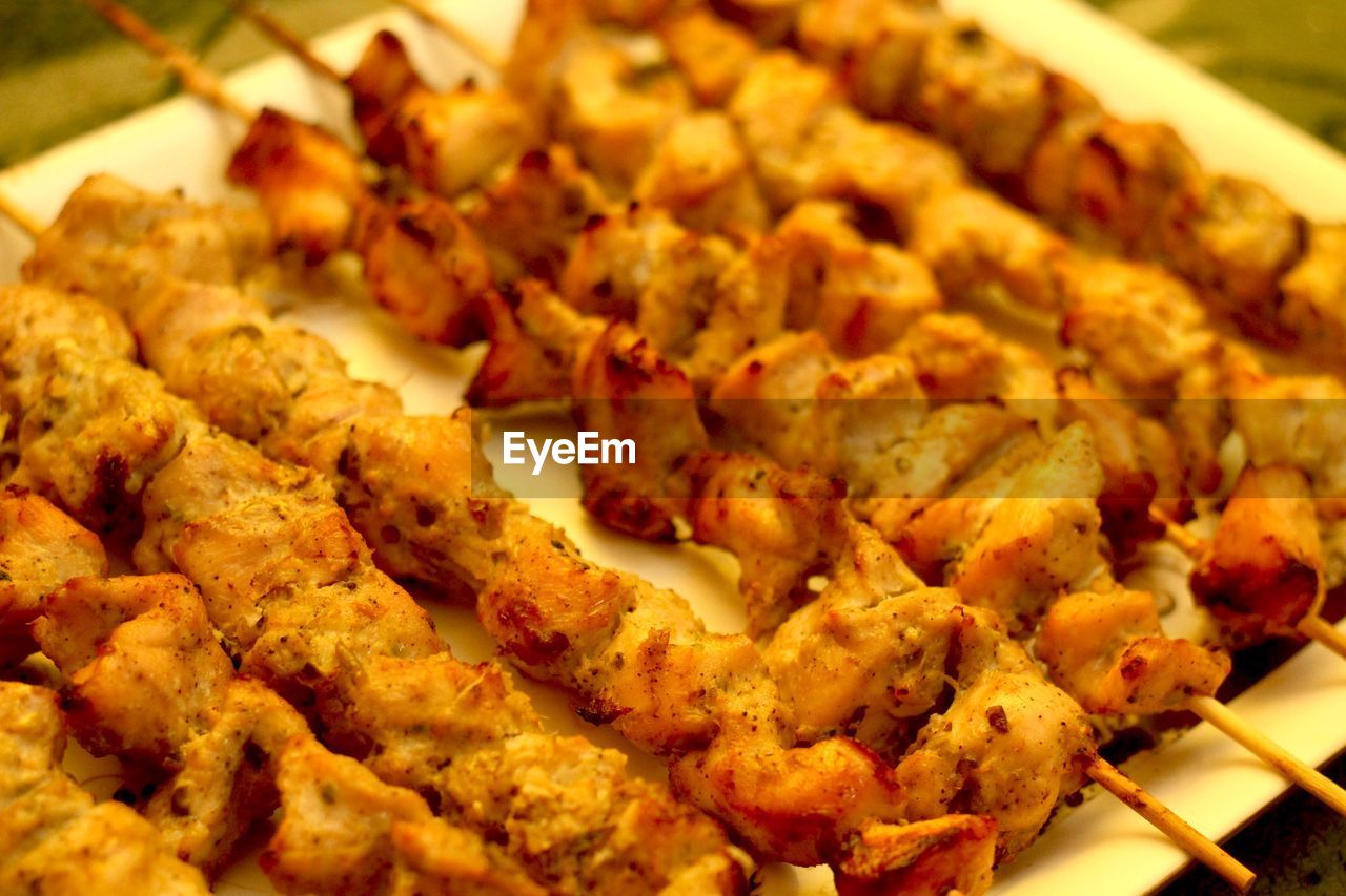 Close-up of fried chicken on skewers in plate