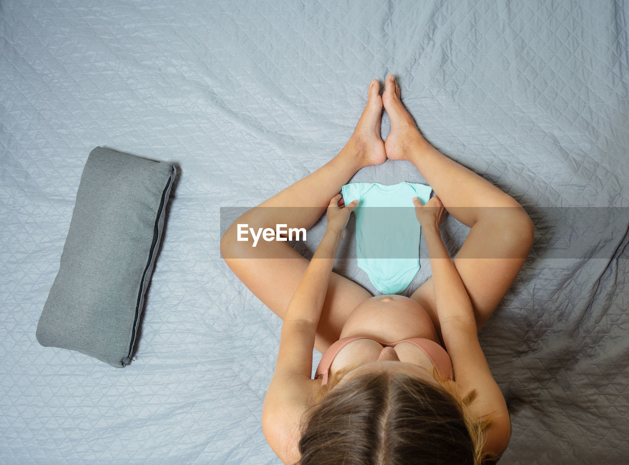 high angle view of young woman lying on bed at home