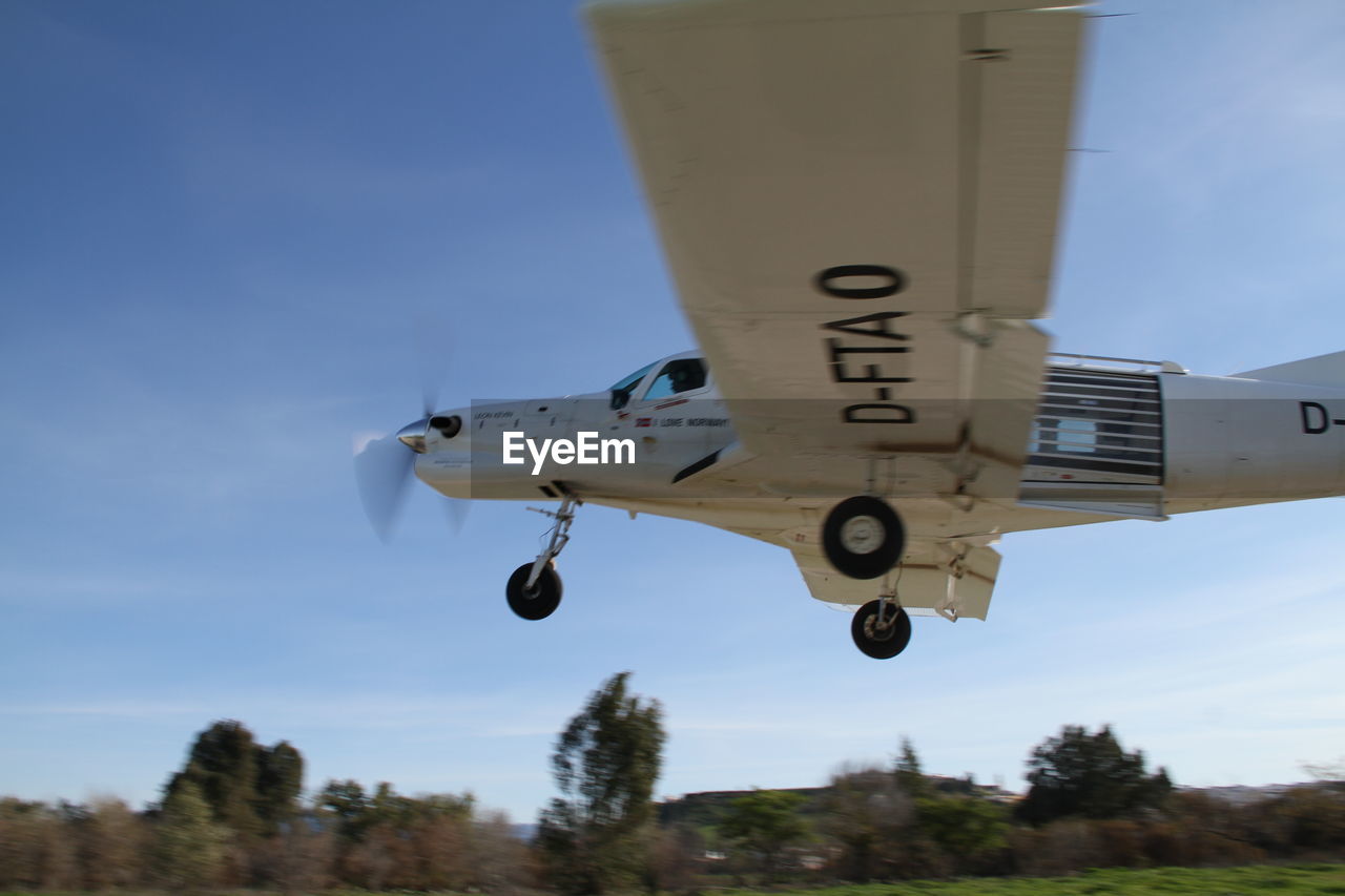 AIRPLANE FLYING AGAINST SKY