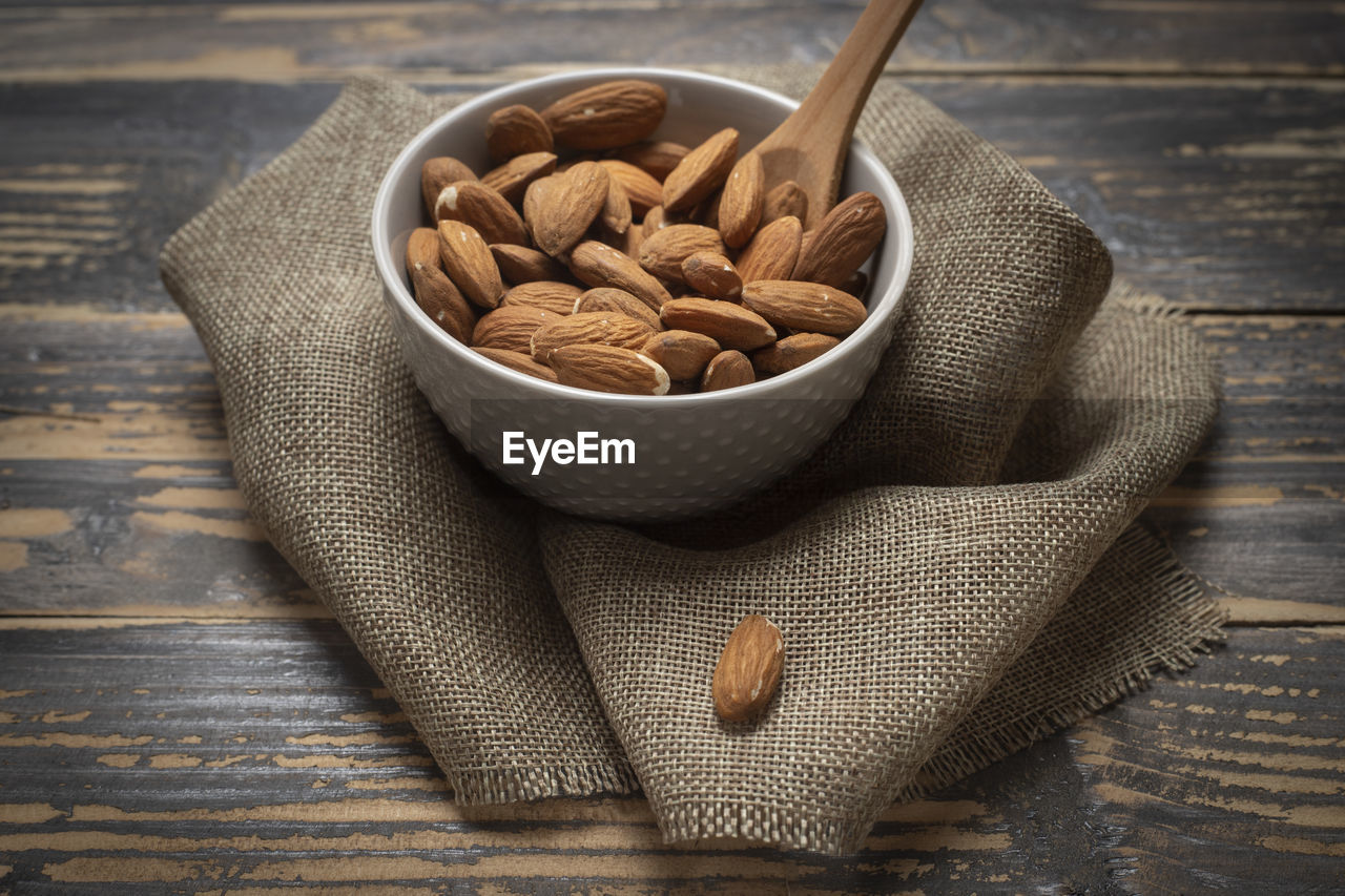 food and drink, food, wood, healthy eating, wellbeing, bowl, indoors, studio shot, spoon, eating utensil, freshness, kitchen utensil, nut - food, produce, nut, still life, no people, high angle view, tableware, fruit, almond, nuts & seeds, table, close-up, burlap, crockery