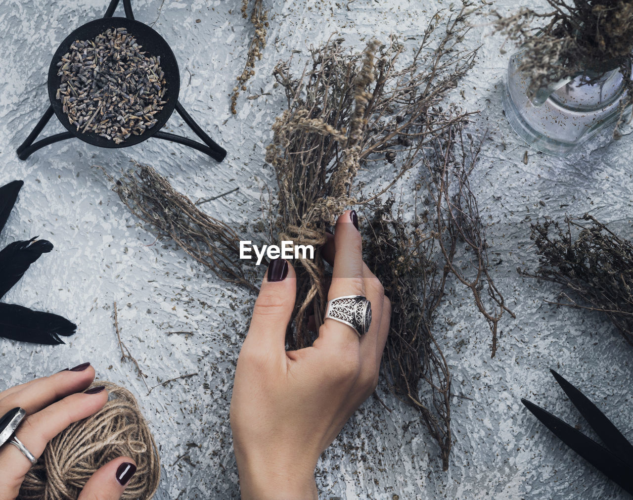 Cropped hands of woman holding dried plants during witchcraft