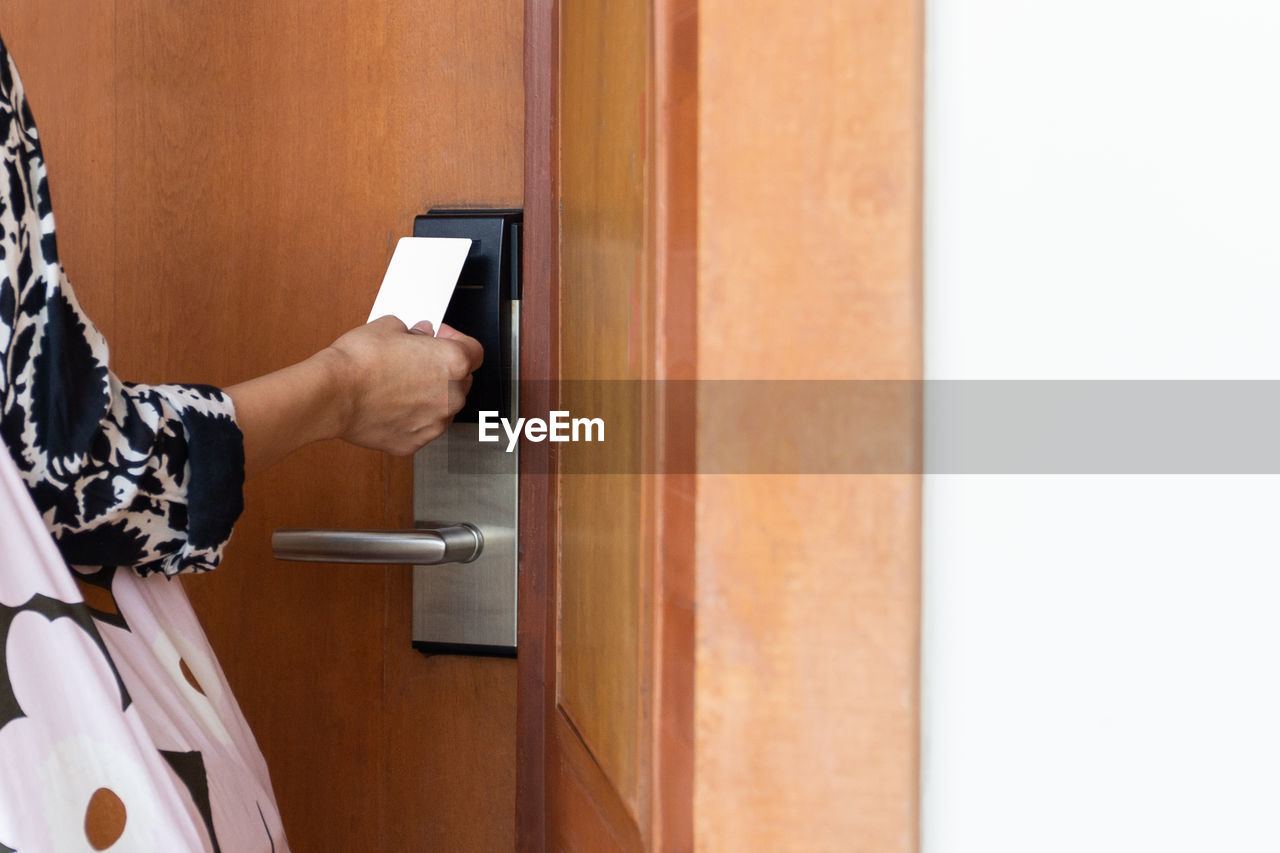 Woman's open hotel room with electronic key card.