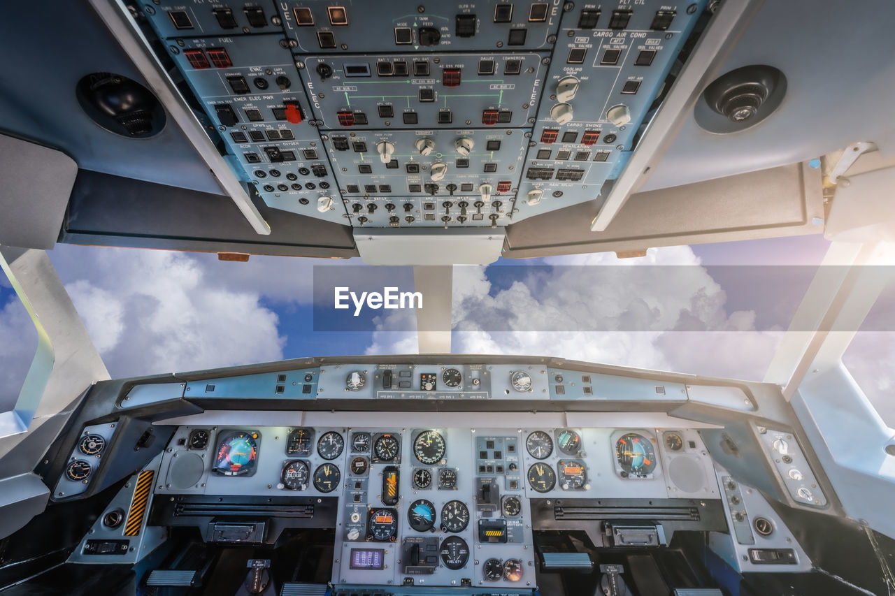 Cockpit with control panel against cloudy sky