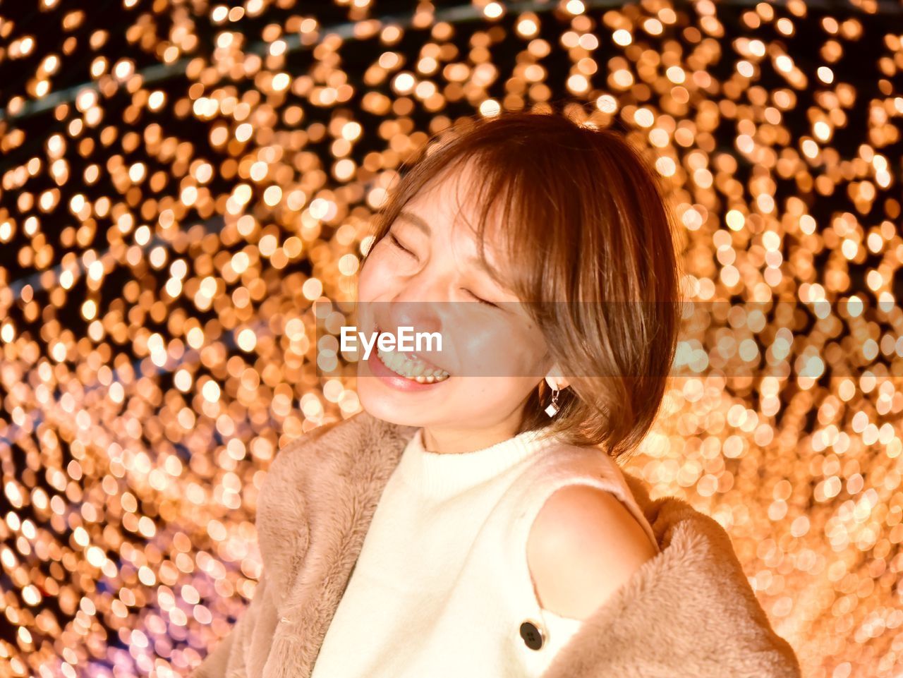 Smiling woman against illuminated lights