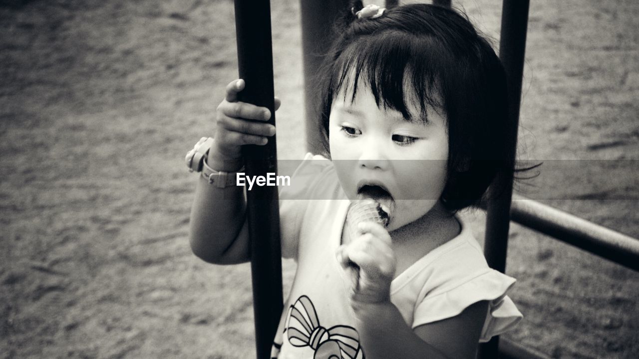 High angle view of girl eating ice cream while standing at park