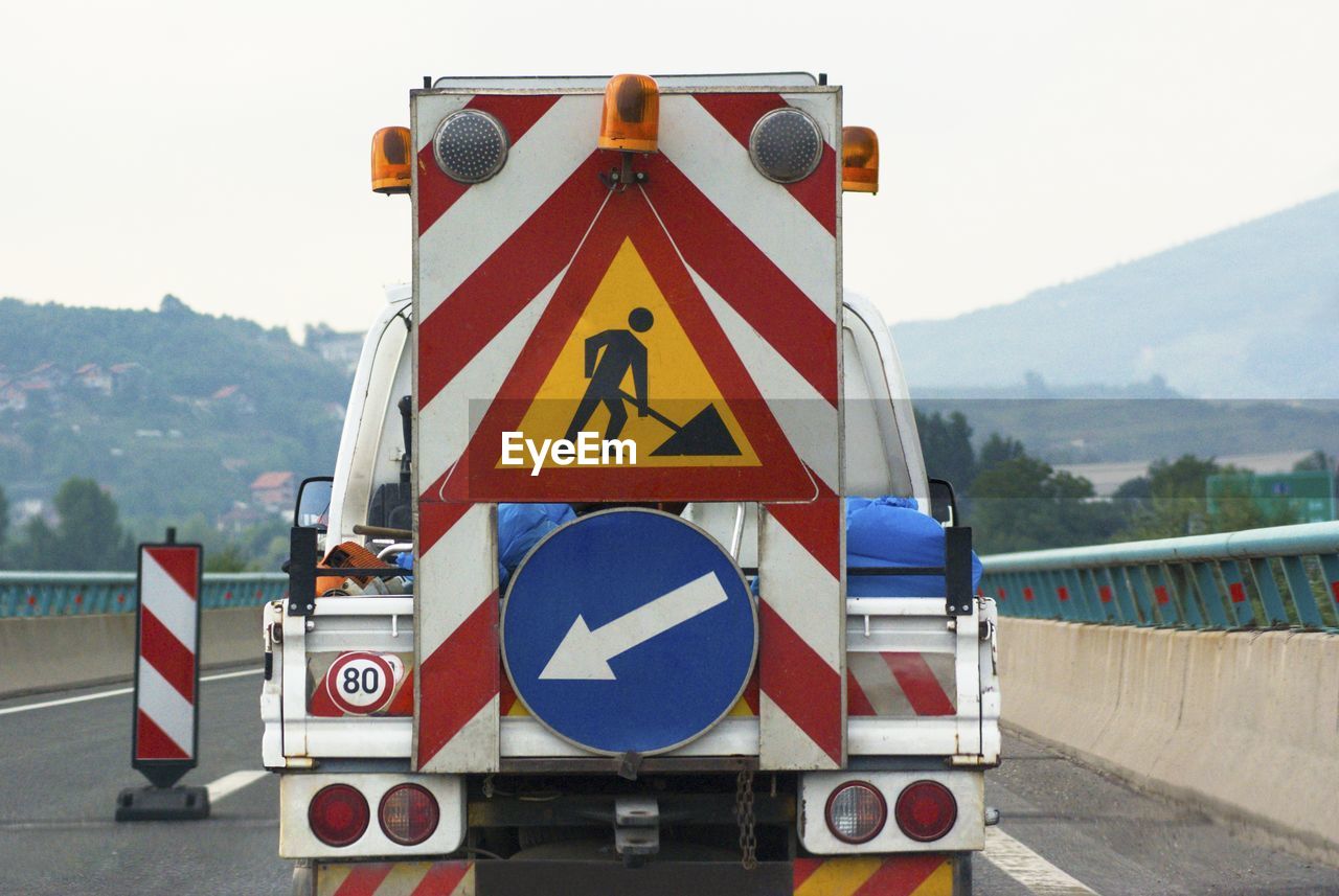 Information sign on the road services truck against sky