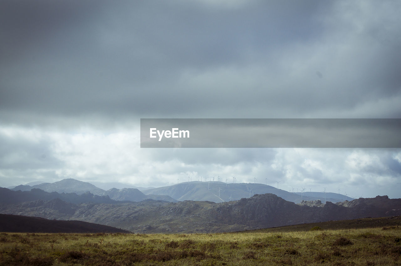 Scenic view of land and mountains against sky