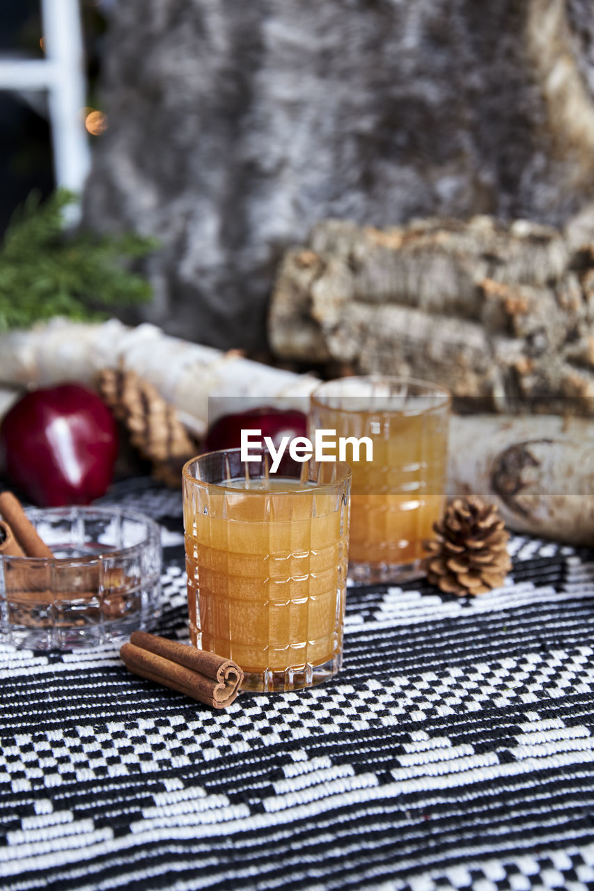 Apple spiced cider served on ice with apple and cinnamon