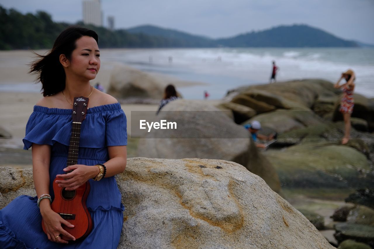 WOMAN ON ROCKS AT BEACH