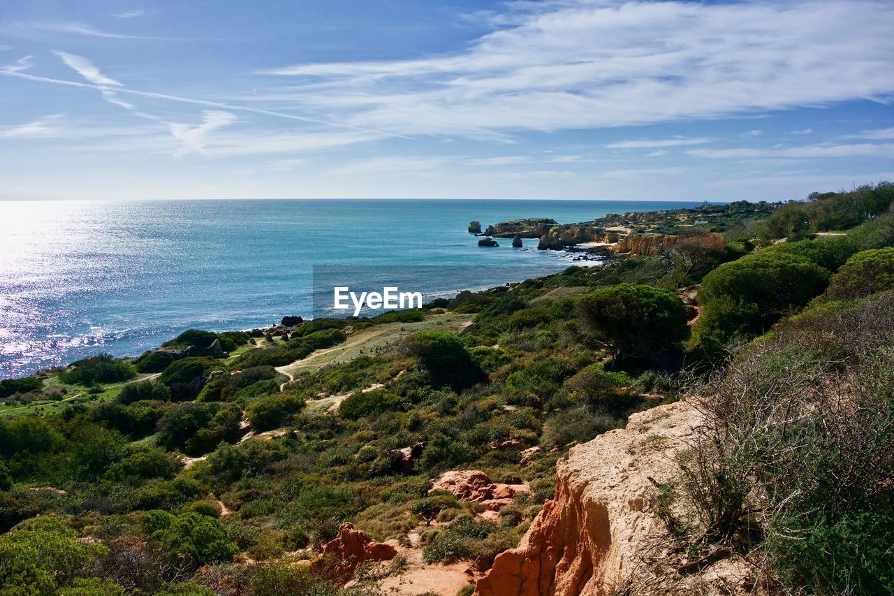 Scenic view of sea and cliff against sky