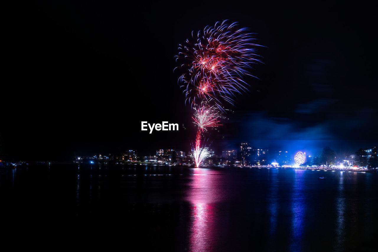 firework display over river at night