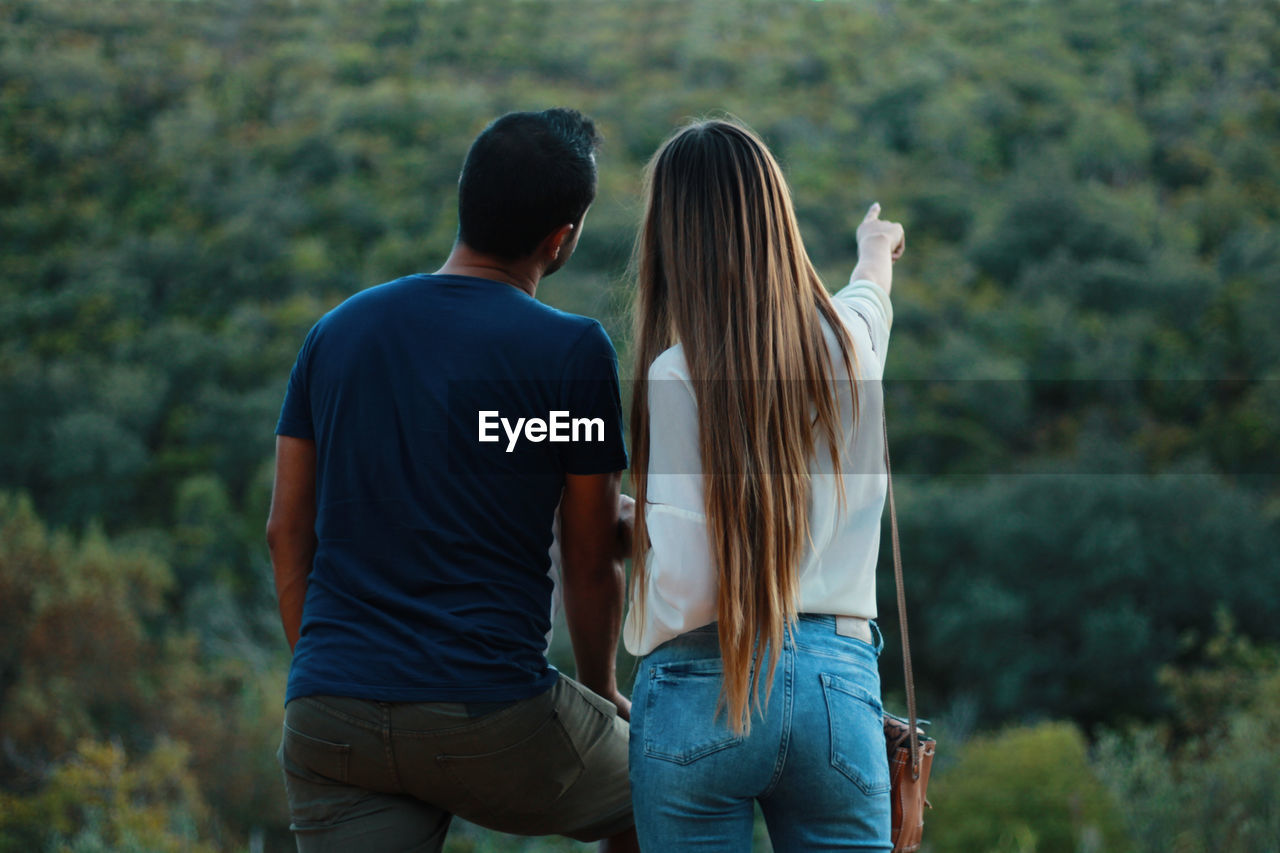 Rear view of couple standing in forest