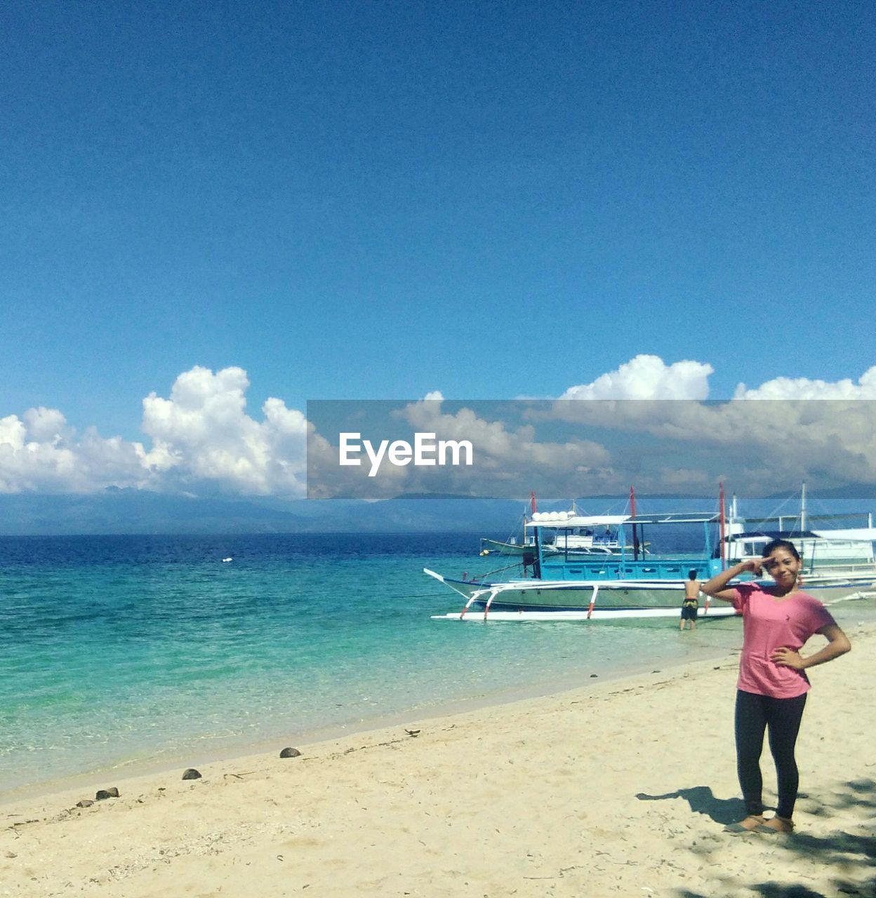 MAN STANDING AT BEACH AGAINST SKY