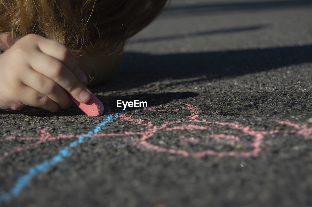 Close-up of child chalk drawing on road