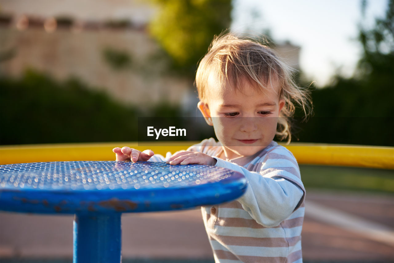 Close-up of boy holding play equipment at playground