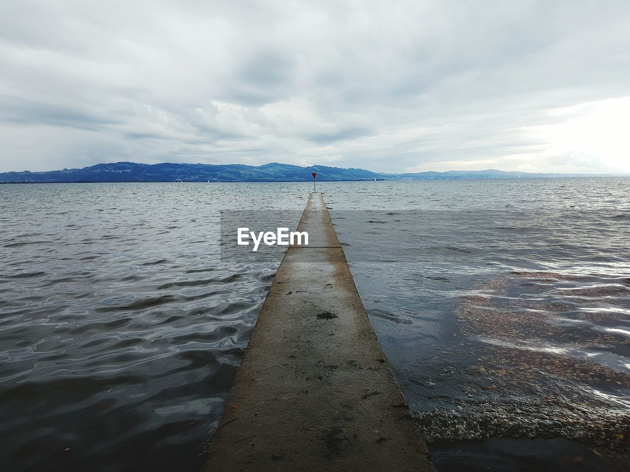 Surface level of sea against cloudy sky