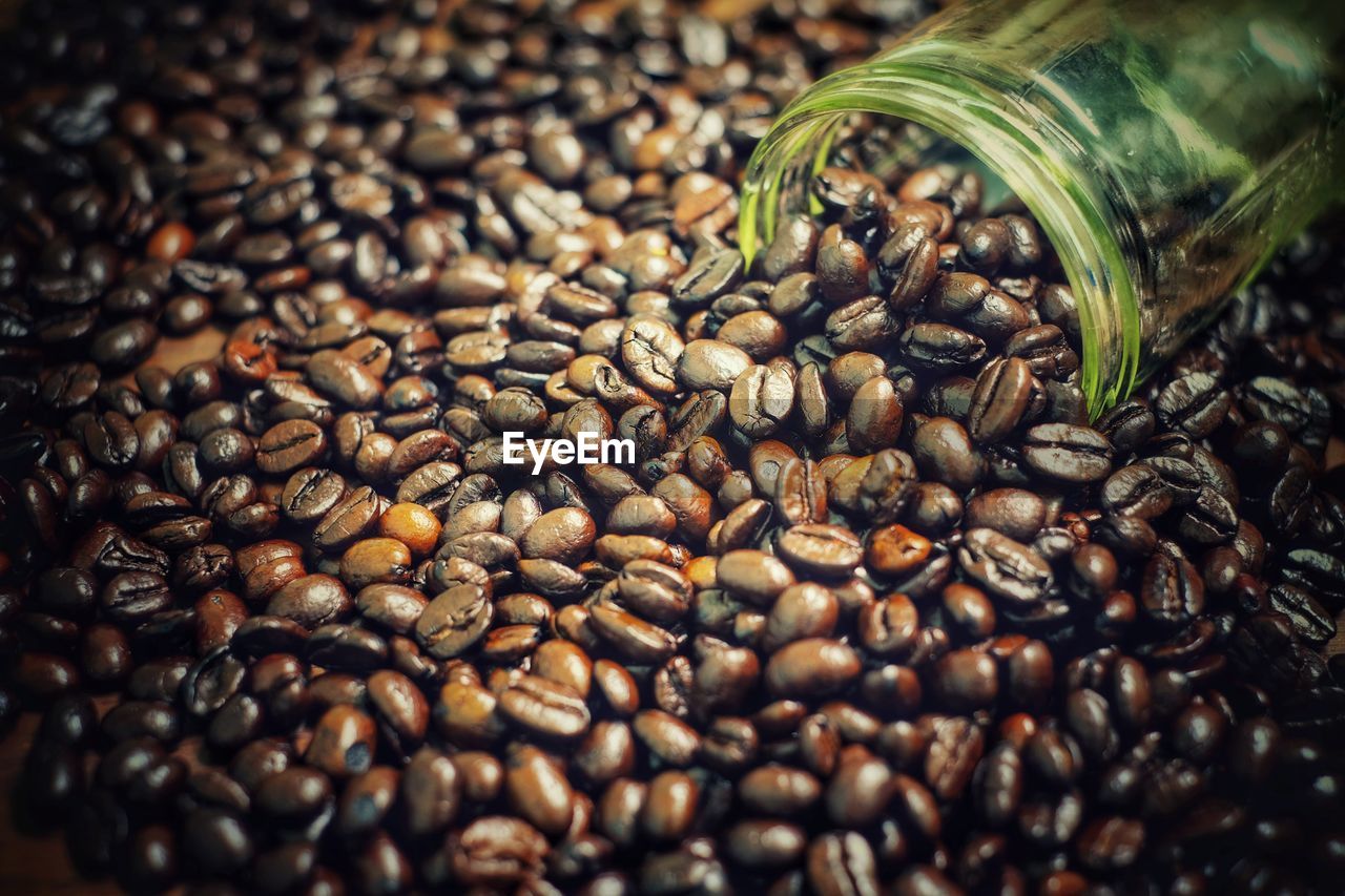 CLOSE-UP OF ROASTED COFFEE BEANS IN BACKGROUND