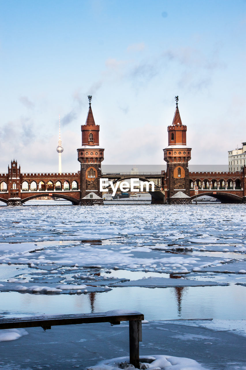 Bridge over river in city during winter