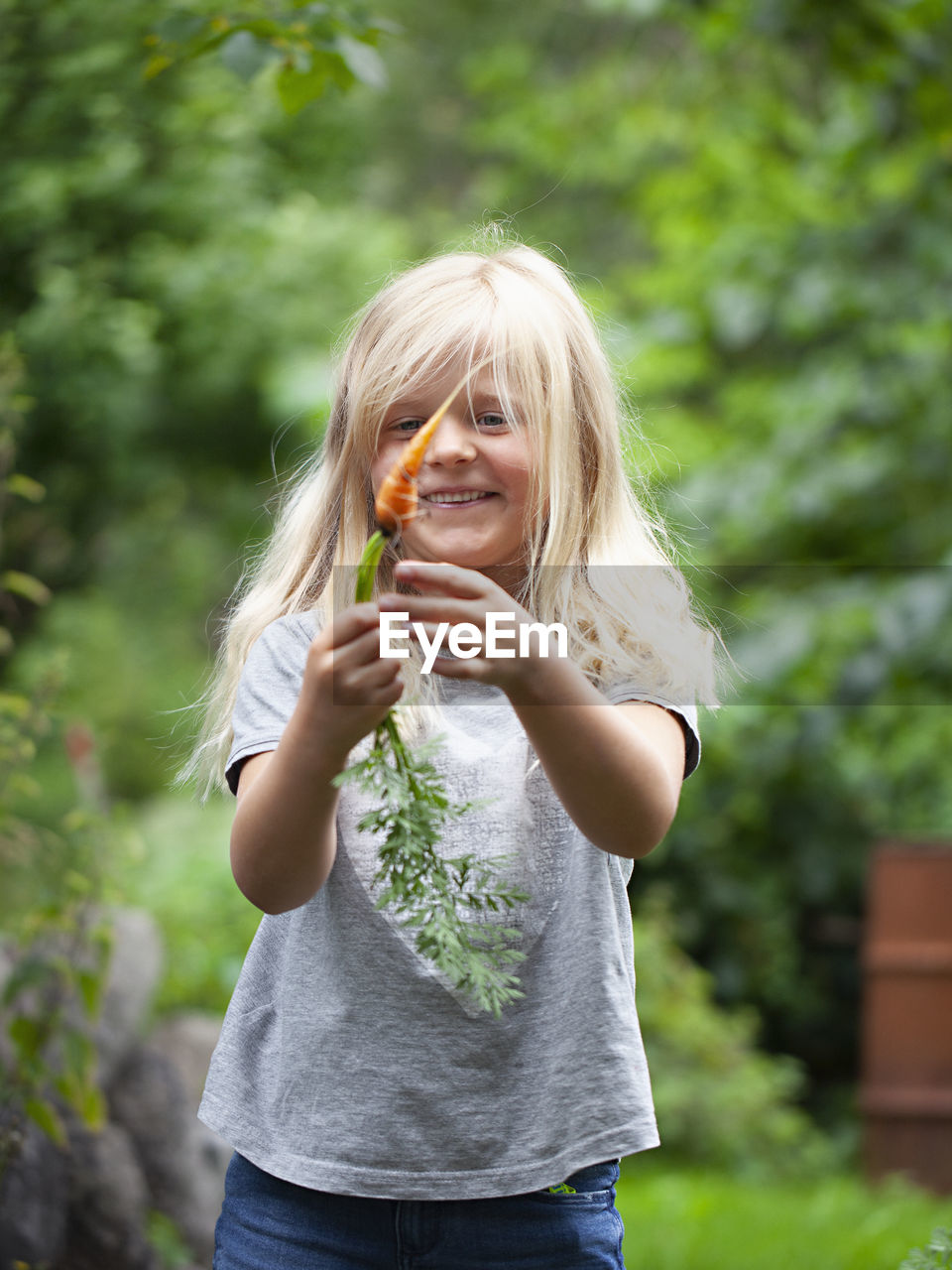 Smiling girl holding carrot