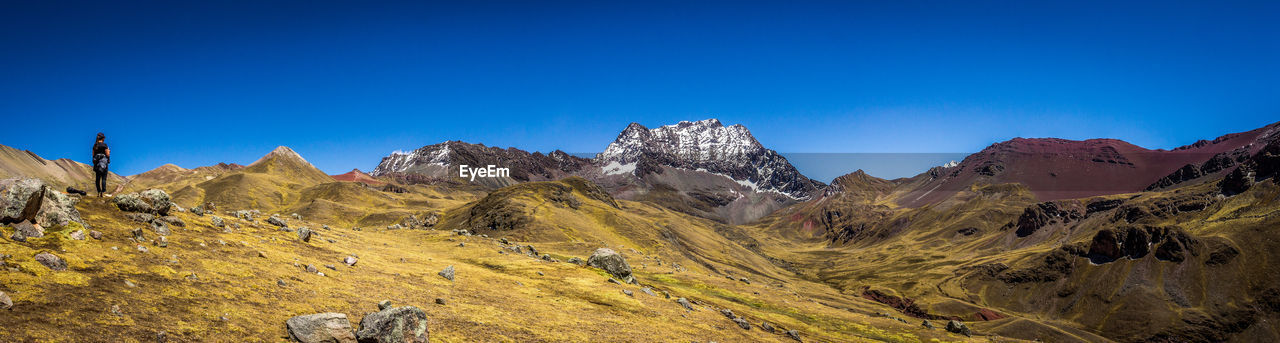 Panoramic view of snowcapped mountains against blue sky