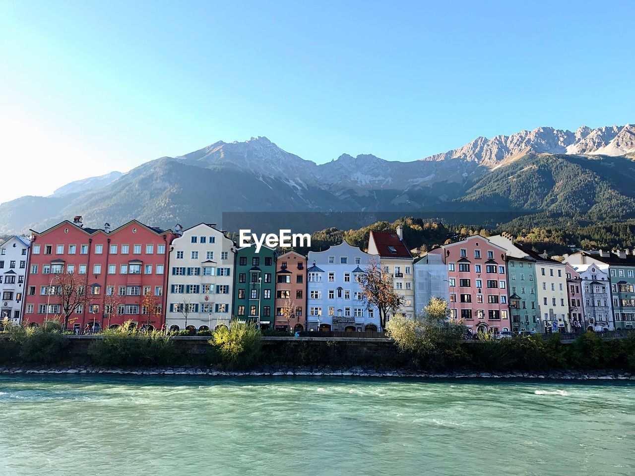 Houses by mountains against clear blue sky