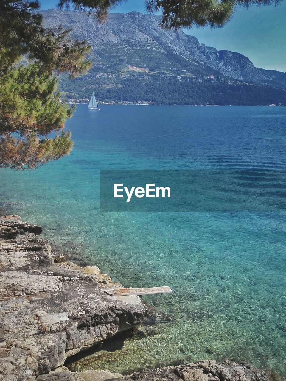 Scenic view of blue sea in front of mountain
