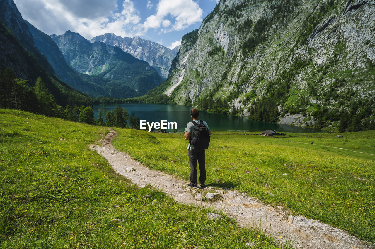 FULL LENGTH REAR VIEW OF MAN STANDING ON MOUNTAIN