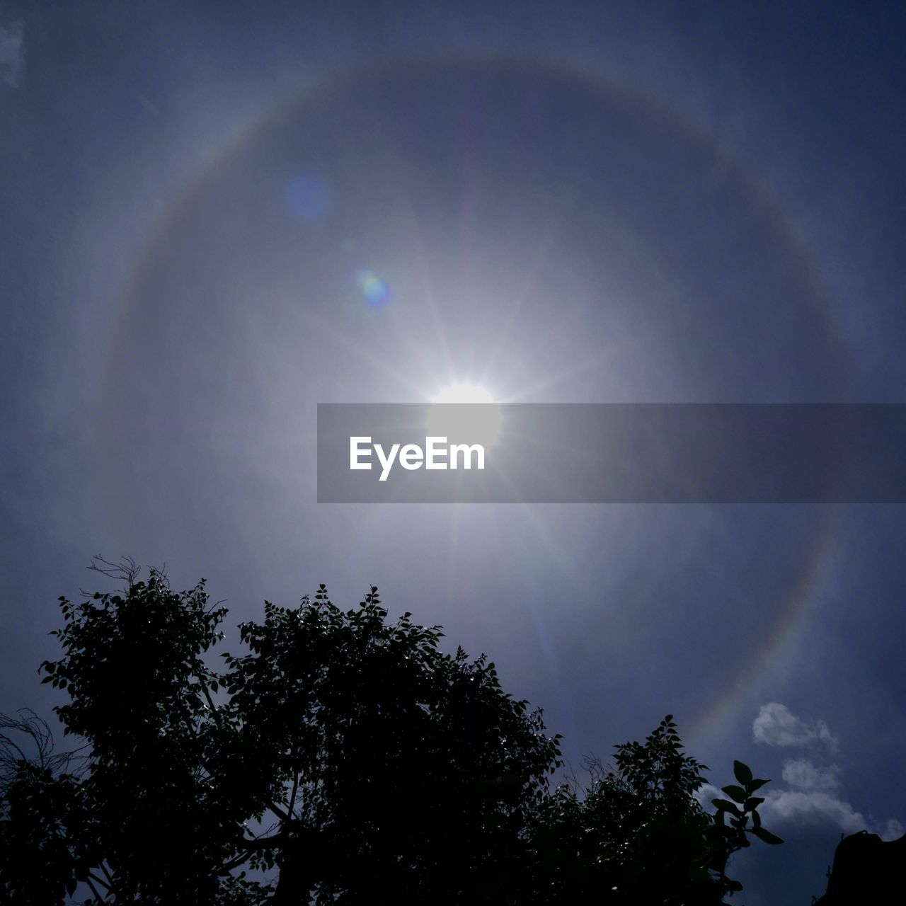 LOW ANGLE VIEW OF SUN SHINING THROUGH CLOUDS