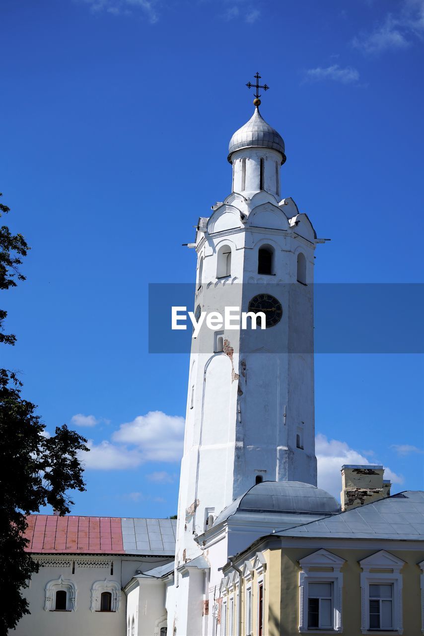 LOW ANGLE VIEW OF BUILDING AND TOWER AGAINST BLUE SKY