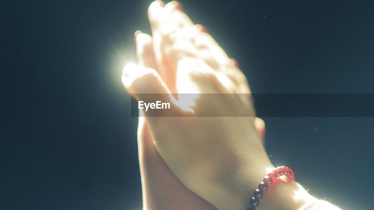 CLOSE-UP OF WOMAN HAND HOLDING ILLUMINATED LIGHT