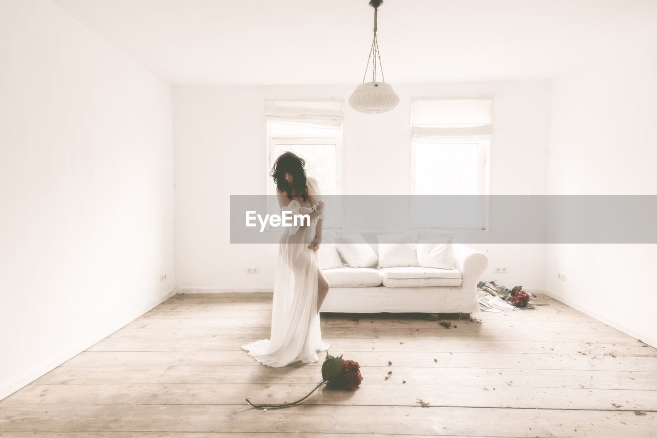 FULL LENGTH OF WOMAN SITTING ON WHITE HOME