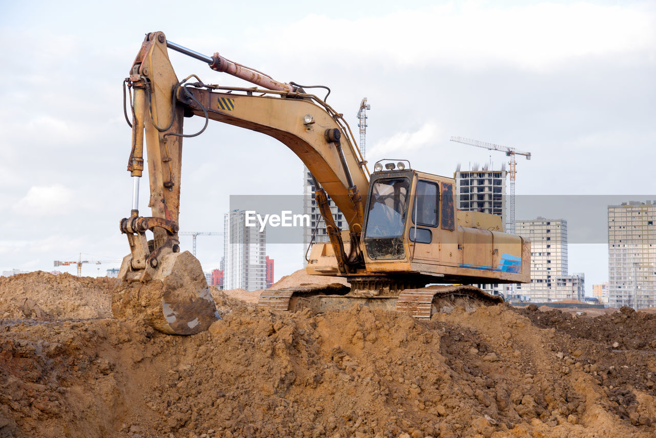 Yellow excavator during earthworks at construction site. backhoe digging the ground