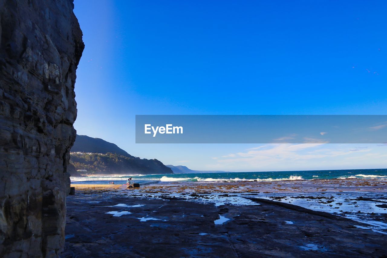 water, sea, ocean, sky, coast, land, scenics - nature, nature, beach, beauty in nature, blue, reflection, environment, shore, rock, body of water, landscape, travel destinations, horizon, travel, wave, mountain, tranquility, no people, cliff, bay, terrain, coastline, outdoors, tranquil scene, clear sky, day, ice, cold temperature, cloud, snow, tourism, non-urban scene, dusk, winter, sunlight, holiday