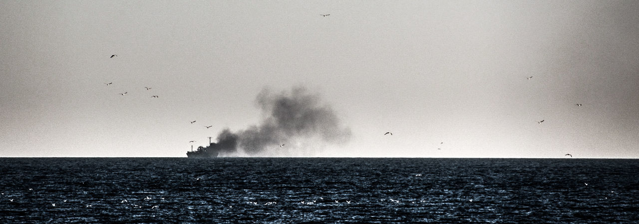 Ship at sea horizon against clear sky