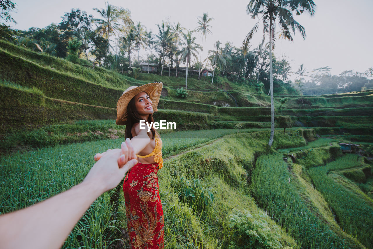 Young woman holding hand at rice terrace