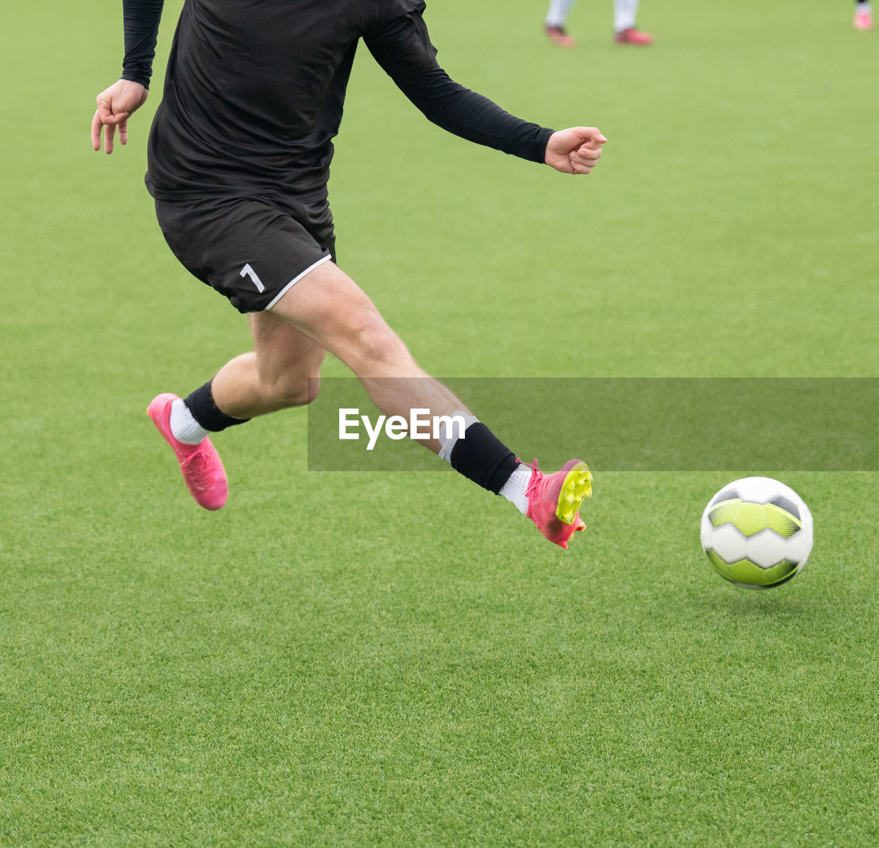 low section of person playing soccer at park