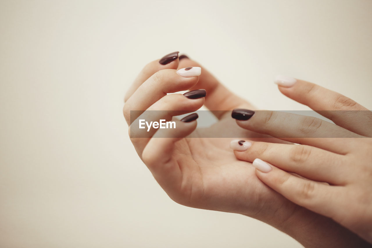 cropped hand of person using mobile phone against white background