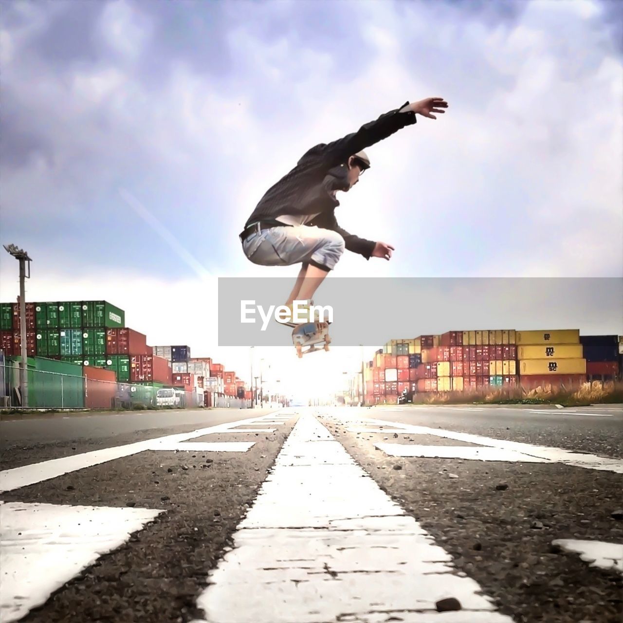 Low angle view of young man skateboarding on road