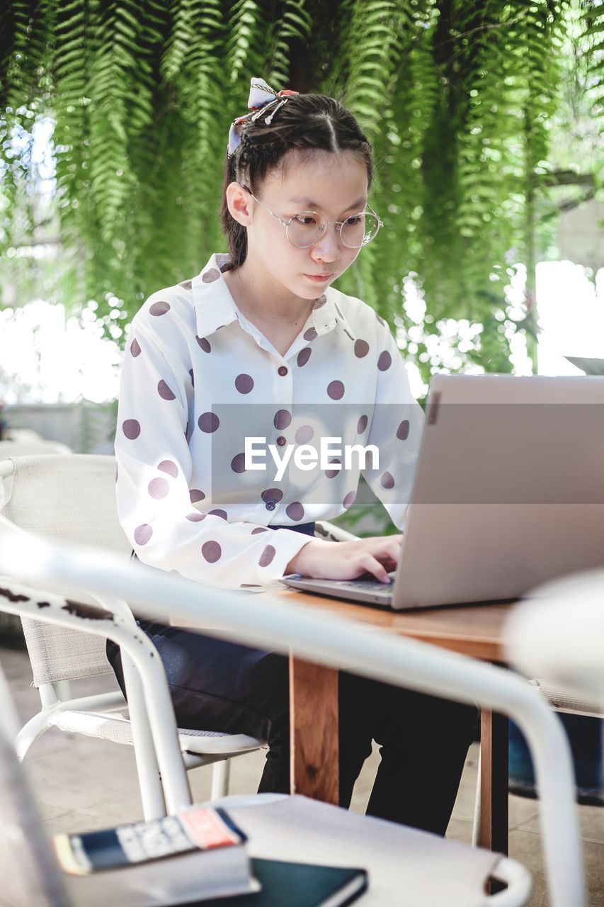 Young women using laptop while sitting on table work at home. new normal lifestyle concept