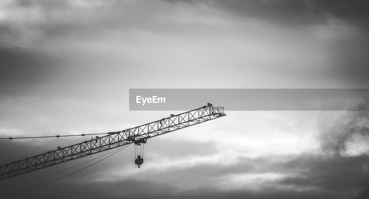 High section of crane against clouds