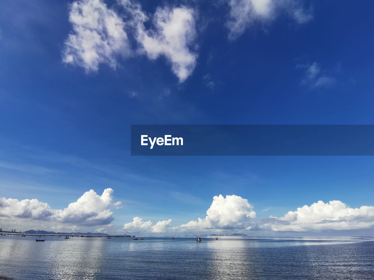 Scenic view of sea against blue sky with cloud