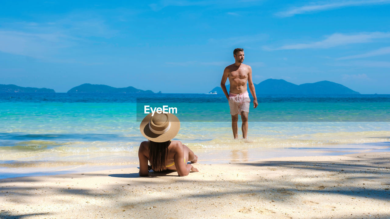 rear view of woman standing at beach