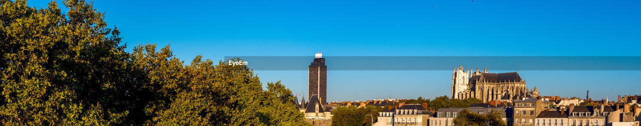 Panoramic view of buildings against blue sky