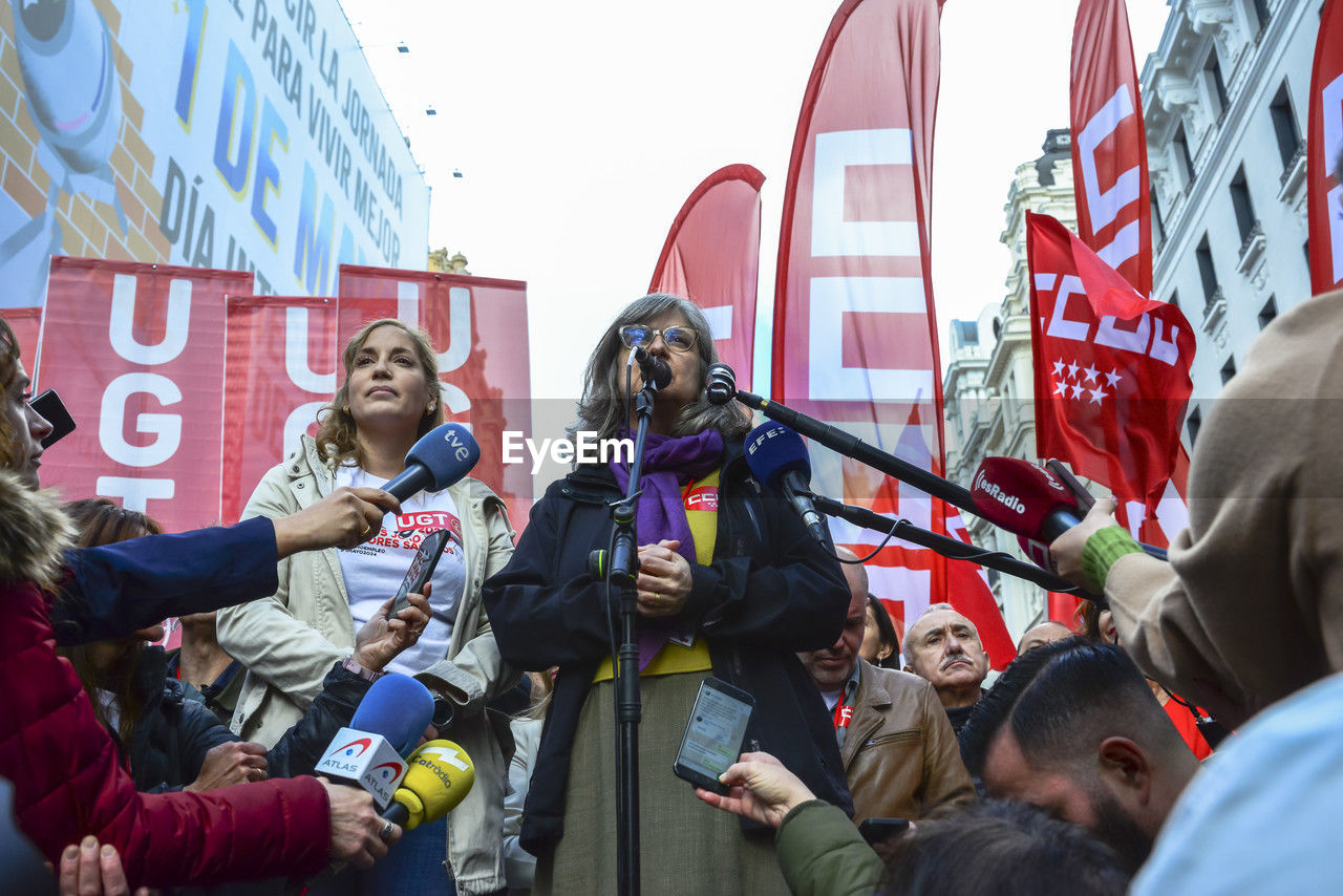 crowd, group of people, protest, adult, men, women, day, young adult, person, togetherness, architecture, city, communication, standing, outdoors, building exterior, clothing, education, large group of people, candid, holding