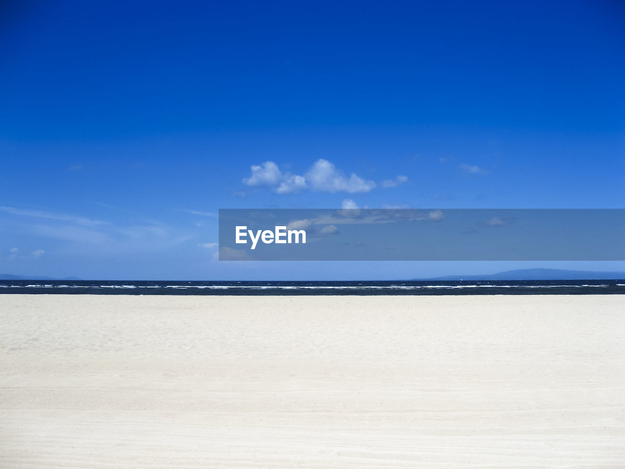 Scenic view of beach against blue sky