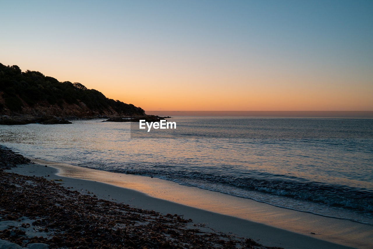 Scenic view of sea against clear sky during sunset