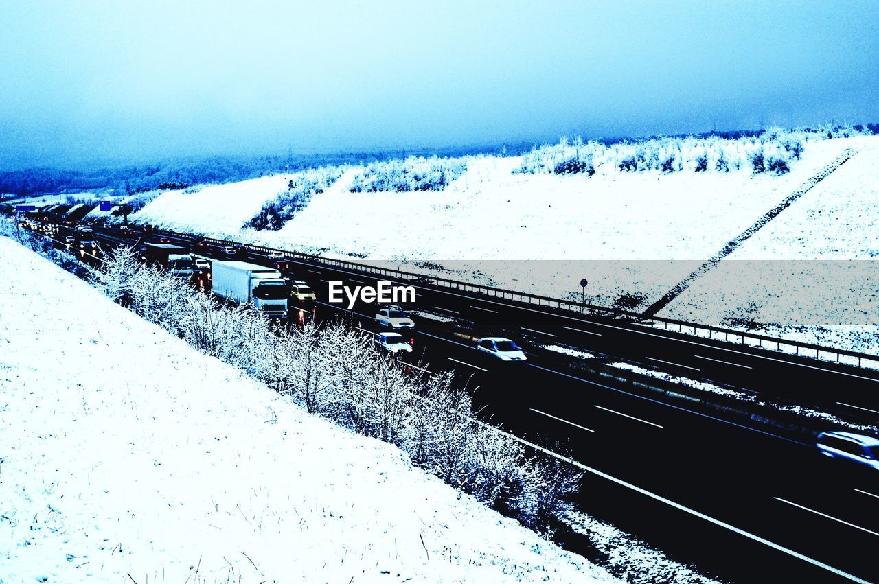 Two lane highway amidst snow covered fields