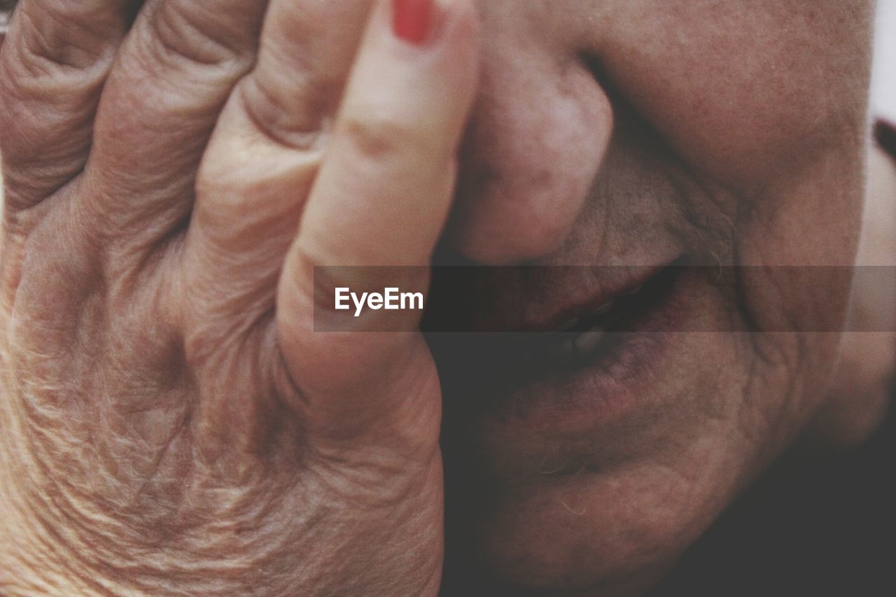 Close-up of woman covering face with hand